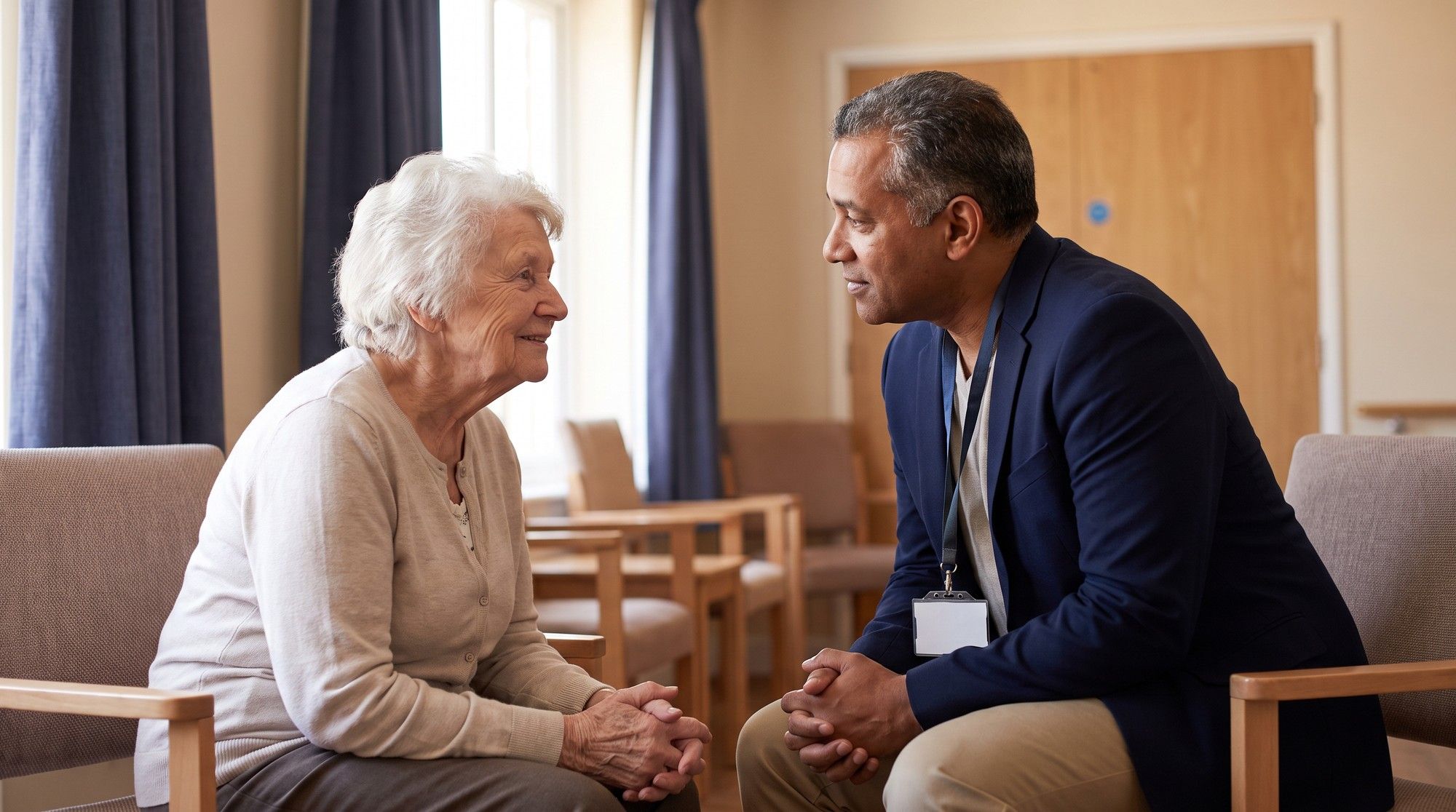 Long-term care ombudsman listening privately to an elderly nursing home resident. Illustration for California Nursing Home Emotional Abuse Lawyers.